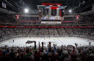 People cheer on the Minnesota Wild during a hockey game in Saint Paul