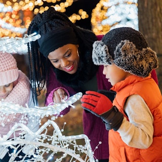 A mother and her children marvel at Christmas lights during the GLOW Holiday Festival.